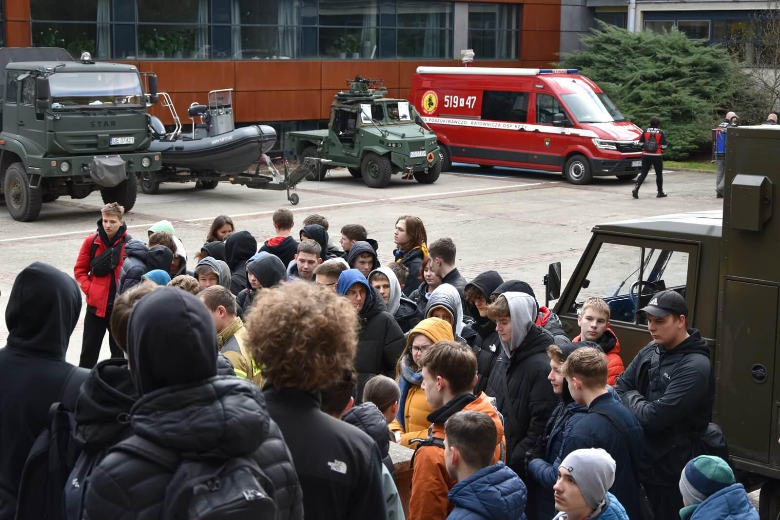 Dziedziniec szkolny. Samochody wojskowe i straży pożarnej.