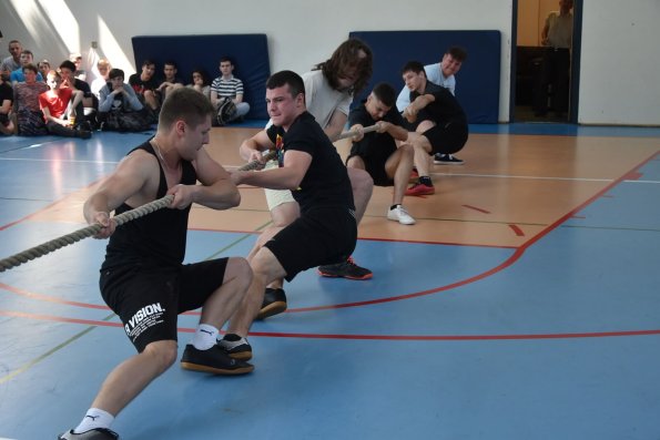 Uczniowie na dużej sali gimnastycznej podczas przeciągania liny.