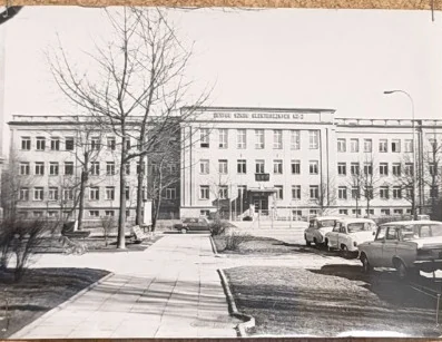 Autentyczna fotografia budynku szkoły z archiwalnej gabloty, ujęcie z dawnego okresu