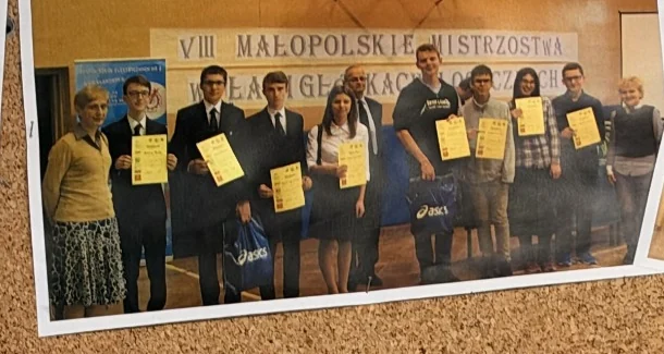 Łamigłówki logiczne — Uczniowie i opiekunowie podczas konkursu. Fotografia z gabloty szkolnej.